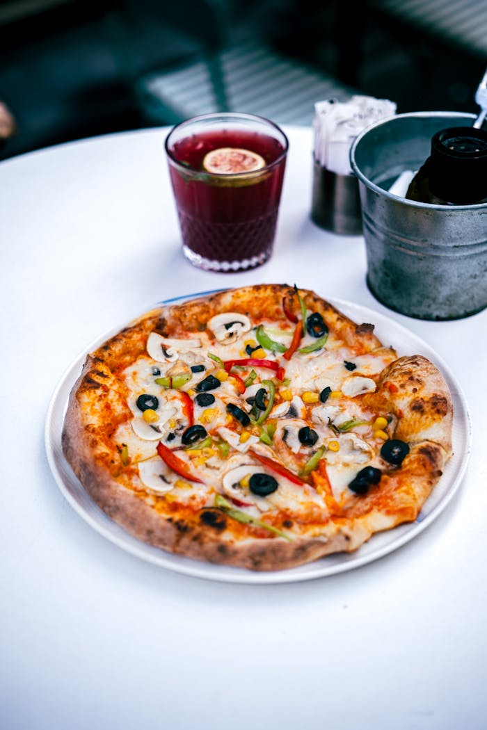 A freshly baked vegetable pizza served indoors on a modern white table.